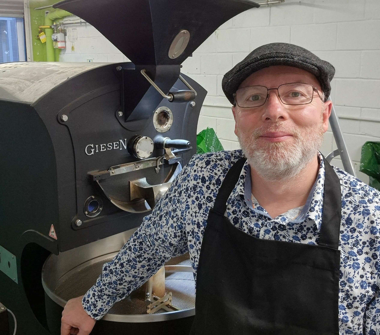 An image of Dave Nixon stood in front of the coffee roaster in the Leeds roastery